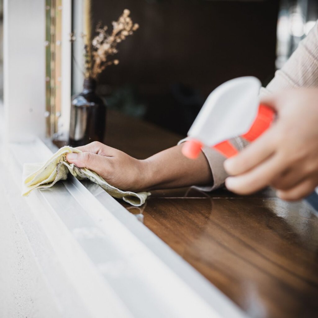 someone cleaning a window sill